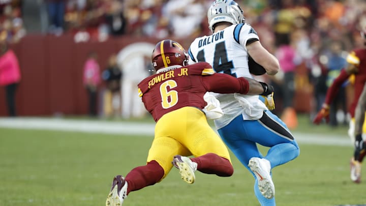 Oct 20, 2024; Landover, Maryland, USA; Carolina Panthers quarterback Andy Dalton (14). Is tackled by Washington Commanders linebacker Dante Fowler Jr. (6) during the fourth quarter at Northwest Stadium. Mandatory Credit: Geoff Burke-Imagn Images