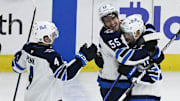 Apr 12, 2025; Chicago, Illinois, USA;  Winnipeg Jets center Cole Perfetti (91) celebrates with  center Mark Scheifele (55) and defenseman Neal Pionk (4) after he scores the game winning shootout goal against the Chicago Blackhawks during the overtime period at United Center. Mandatory Credit: Matt Marton-Imagn Images