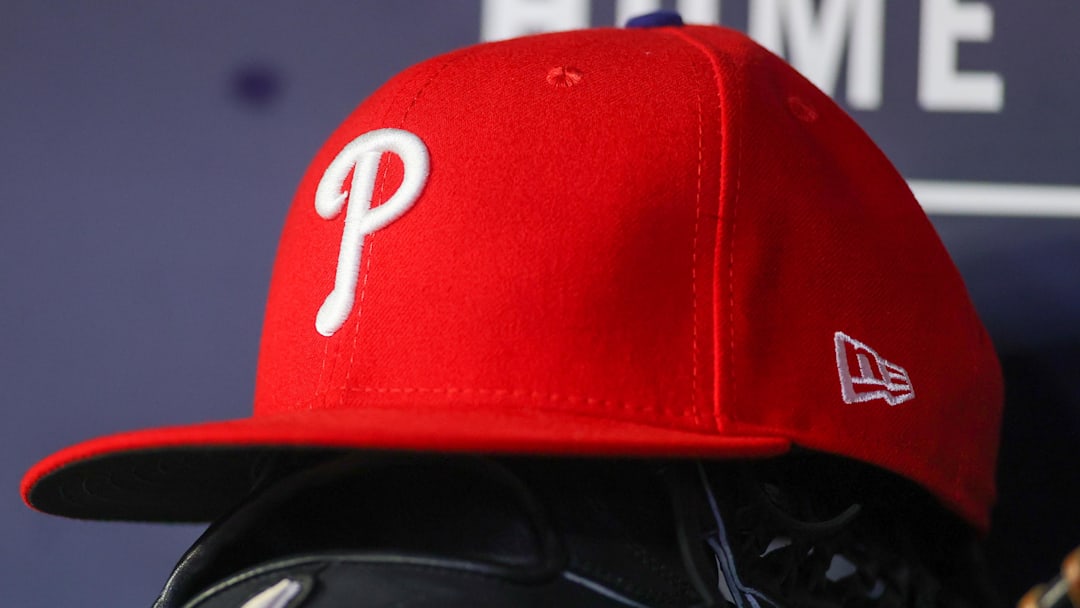 May 26, 2023; Atlanta, Georgia, USA; A detailed view of a Philadelphia Phillies hat and glove on the bench against the Atlanta Braves in the seventh inning at Truist Park. 