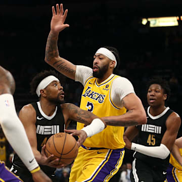 Memphis Grizzlies guard Jordan Goodwin (4) drives to the basket between Los Angeles Lakers forward LeBron James (23) and forward Anthony Davis (3) during the second half at FedExForum.