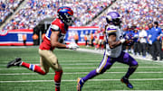 Sep 8, 2024; East Rutherford, New Jersey, USA; Minnesota Vikings running back Aaron Jones (33) runs for a touchdown as New York Giants cornerback Nick McCloud (44) defends during the first half at MetLife Stadium. Mandatory Credit: John Jones-Imagn Images