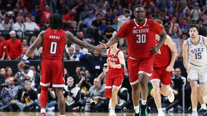 Mar 31, 2024; Dallas, TX, USA; North Carolina State Wolfpack forward DJ Burns Jr. (30) and guard DJ Horne (0) react in the second half against the Duke Blue Devils in the finals of the South Regional of the 2024 NCAA Tournament at American Airline Center. Mandatory Credit: Tim Heitman-USA TODAY Sports