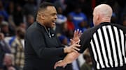 Feb 4, 2023; Memphis, Tennessee, USA; Tulane Green Wave head coach Ron Hunter (left) talks with an official during a timeout during the second half against the Memphis Tigers at FedExForum.