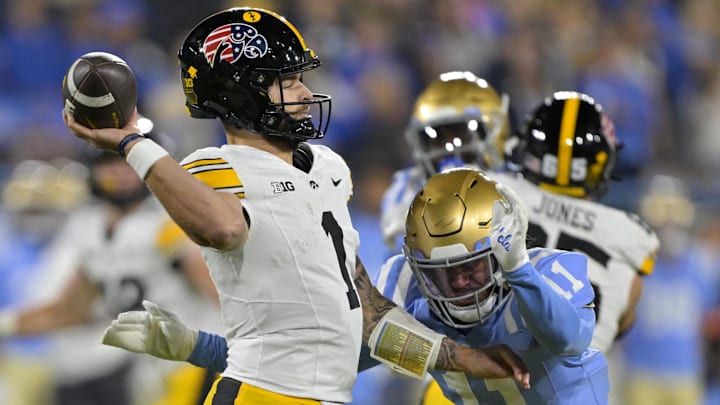 Nov 8, 2024; Pasadena, California, USA;   Iowa Hawkeyes quarterback Brendan Sullivan (1) is pressured by UCLA Bruins defensive back Ramon Henderson (11) as he throws an incomplete pass in the first half at the Rose Bowl. Mandatory Credit: Jayne Kamin-Oncea-Imagn Images