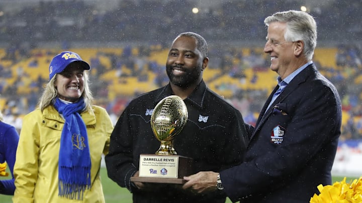 Oct 14, 2023; Pittsburgh, Pennsylvania, USA; Pittsburgh Panthers Athletic Director Heather Lyke (left) and Professional Football Hall of Fame trustee Dennis Nash (right) present a trophy to Pro Football hall of Fame and former Pittsburgh defensive back Darrell Revis (middle) between quarters of the game against the Louisville Cardinals at Acrisure Stadium. Pittsburgh won 38-21. Mandatory Credit: Charles LeClaire-Imagn Images