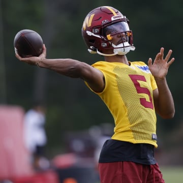 Jul 26, 2024; Ashburn, VA, USA; Washington Commanders quarterback Jayden Daniels (5) passes the ball during warmup before day three of training camp at Commanders Park. Mandatory Credit: Geoff Burke-USA TODAY Sports