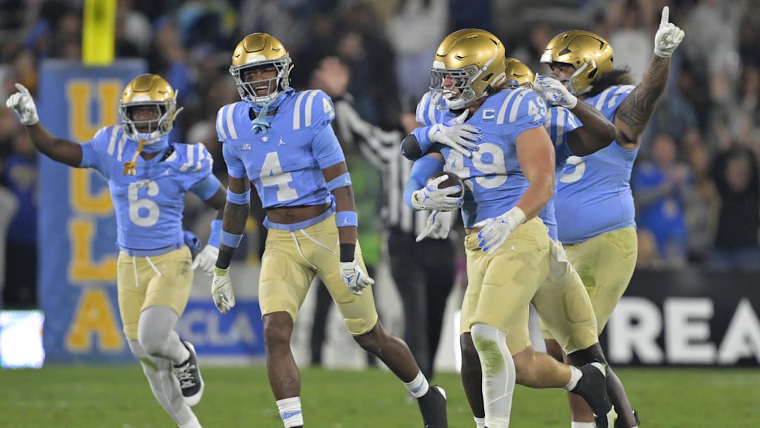 Nov 8, 2024; Pasadena, California, USA;   UCLA Bruins linebacker Carson Schwesinger (49) and teammates celebrate after an interception in the second half against the Iowa Hawkeyes at the Rose Bowl. Mandatory Credit: Jayne Kamin-Oncea-Imagn Images