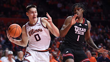 Nov 11, 2025; Champaign, Illinois, USA; IIllinois Fighting Illini forward David Mirkovic (0) drives past Texas Tech Red Raiders guard Tyree Bryan (1) during the first half at State Farm Center. Mandatory Credit: Ron Johnson-Imagn Images