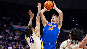 Feb 22, 2025; Baton Rouge, Louisiana, USA;  Florida Gators forward Thomas Haugh (10) drives to the basket against LSU Tigers guard Dji Bailey (4) during the second half at Pete Maravich Assembly Center. Mandatory Credit: Stephen Lew-Imagn Images