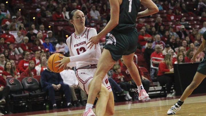 Wisconsin's Tessa Grady (12) attempts to make a pass as Michigan State's Tory Ozment on Sunday March 3, 2024 at the Kohl Center in Madison, Wisconsin.