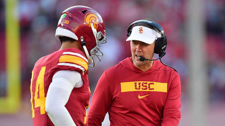Nov 16, 2024; Los Angeles, California, USA; Southern California Trojans head coach Lincoln Riley greets quarterback Jayden Maiava (14) after scoring a touchdown against the Nebraska Cornhuskers during the second half at the Los Angeles Memorial Coliseum. Mandatory Credit: Gary A. Vasquez-Imagn Images