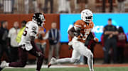 Nov 28, 2025; Austin, Texas, USA; Texas Longhorns running back Quintrevion Wisner (5) runs for yards past Texas A&M Aggies safety Dalton Brooks (25) during the second half at Darrell K Royal-Texas Memorial Stadium. Mandatory Credit: Scott Wachter-Imagn Images