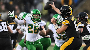 Nov 8, 2025; Iowa City, Iowa, USA; Oregon Ducks linebacker Bryce Boettcher (28) pressures Iowa Hawkeyes quarterback Mark Gronowski (11) during the second quarter at Kinnick Stadium. Mandatory Credit: Jeffrey Becker-Imagn Images