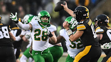 Nov 8, 2025; Iowa City, Iowa, USA; Oregon Ducks linebacker Bryce Boettcher (28) pressures Iowa Hawkeyes quarterback Mark Gronowski (11) during the second quarter at Kinnick Stadium. Mandatory Credit: Jeffrey Becker-Imagn Images