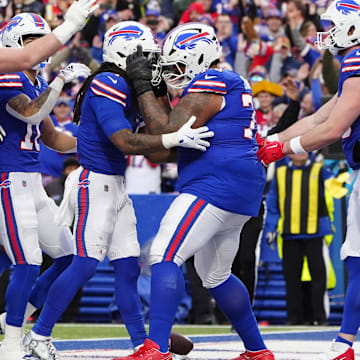 Buffalo Bills offensive tackle Dion Dawkins congratulates running back James Cook for scoring a touchdown.