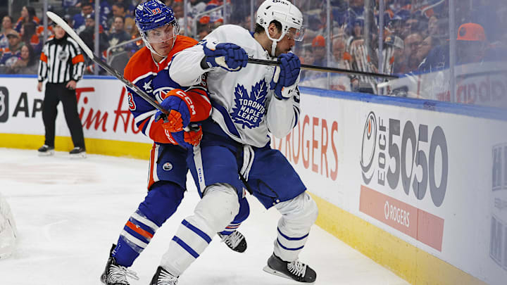 Feb 1, 2025; Edmonton, Alberta, CAN; Toronto Maple Leafs forward Auston Matthews (34) and Edmonton Oilers forward Ryan Nugent-Hopkins (93) battle along the boards for a loose puck during the second period at Rogers Place. Mandatory Credit: Perry Nelson-Imagn Images