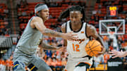 Jan 27, 2024; Stillwater, Oklahoma, USA; Oklahoma State Cowboys guard Javon Small (12) drives around West Virginia Mountaineers guard RaeQuan Battle (21) during the first half at Gallagher-Iba Arena. Mandatory Credit: William Purnell-Imagn Images