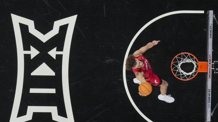 Jan 9, 2024; Cincinnati, Ohio, USA;  The Big 12 Conference logo is seen during warmups as Cincinnati Bearcats guard Dan Skillings Jr. drives to the basket before a game against the Texas Longhorns at Fifth Third Arena. Mandatory Credit: Aaron Doster-USA TODAY Sports