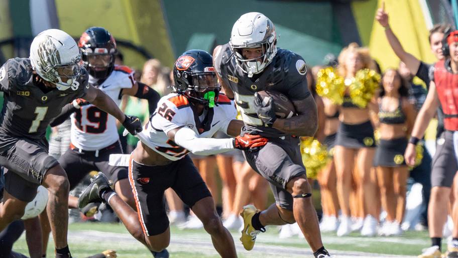 Oregon Ducks running back Makhi Hughes attempts to break a tackle by Oregon State Beavers defensive back Harlem Howard.