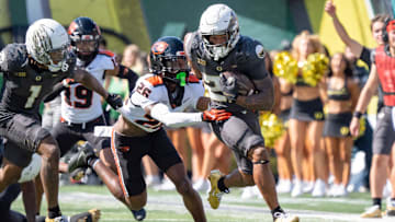 Oregon Ducks running back Makhi Hughes attempts to break a tackle by Oregon State Beavers defensive back Harlem Howard as the Oregon Ducks host the Oregon State Beavers Sept. 20, 2025, at Autzen Stadium in Eugene, Oregon.