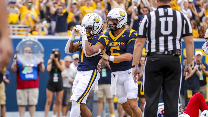 Sep 21, 2024; Morgantown, West Virginia, USA; West Virginia Mountaineers running back Jahiem White (1) celebrates with West Virginia Mountaineers quarterback Garrett Greene (6) after running in for a touchdown during the first quarter against the Kansas Jayhawks at Mountaineer Field at Milan Puskar Stadium. Mandatory Credit: Ben Queen-Imagn Images Sep 21, 2024; Morgantown, West Virginia, USA; West Virginia Mountaineers running back Jahiem White (1) celebrates with West Virginia Mountaineers quarterback Garrett Greene (6) after running in for a touchdown during the first quarter against the Kansas Jayhawks at Mountaineer Field at Milan Puskar Stadium. Mandatory Credit: Ben Queen-Imagn Images