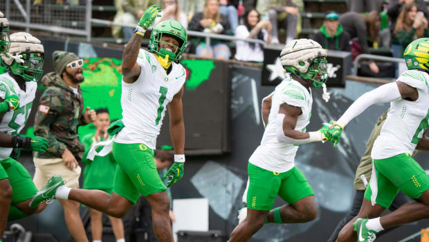 Oregon White Team wide receiver Traeshon Holden waves to the crowd as the team takes the field during the Oregon Ducks’ Sprin