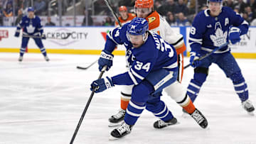 Dec 12, 2024; Toronto, Ontario, CAN; Toronto Maple Leafs forward Auston Matthews (34) battles to get to puck against Anaheim Ducks forward Leo Carlsson (91) during the first period at Scotiabank Arena. Mandatory Credit: John E. Sokolowski-Imagn Images