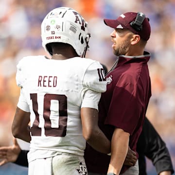 Sep 14, 2024; Gainesville, Florida, USA; Texas A&M Aggies quarterback Marcel Reed (10) celebrates with Texas A&M Aggies offensive coordinator Collin Klein after a touchdown against the Florida Gators during the first half at Ben Hill Griffin Stadium. Mandatory Credit: Matt Pendleton-Imagn Images