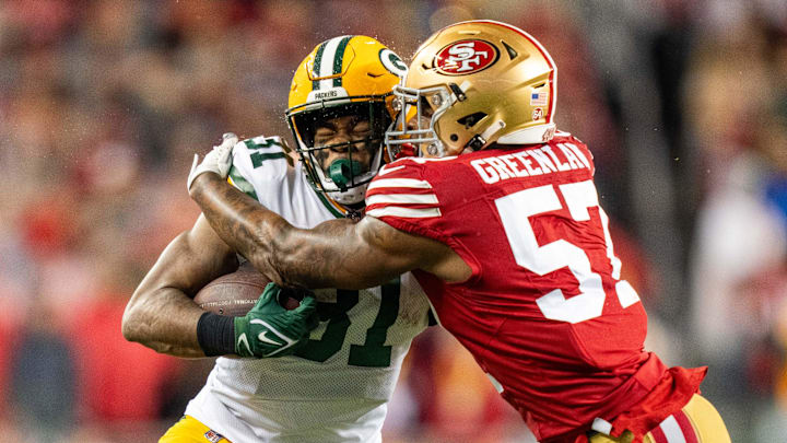 January 20, 2024; Santa Clara, CA, USA; San Francisco 49ers linebacker Dre Greenlaw (57) tackles Green Bay Packers running back Emanuel Wilson (31) during the first quarter in a 2024 NFC divisional round game at Levi's Stadium. Mandatory Credit: Kyle Terada-Imagn Images