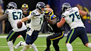 Nov 16, 2025; Inglewood, California, USA; Seattle Seahawks quarterback Sam Darnold (14) runs away from Los Angeles Rams linebacker Byron Young (0) during the second half at SoFi Stadium. Mandatory Credit: Jayne Kamin-Oncea-Imagn Images