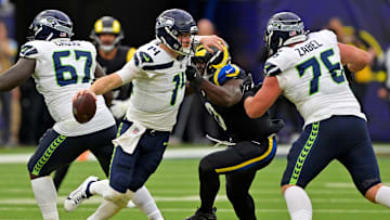 Nov 16, 2025; Inglewood, California, USA; Seattle Seahawks quarterback Sam Darnold (14) runs away from Los Angeles Rams linebacker Byron Young (0) during the second half at SoFi Stadium. Mandatory Credit: Jayne Kamin-Oncea-Imagn Images