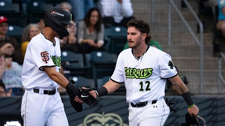 Eugene’s Cole Foster, right, celebrates a run with teammate Scott Bandura during the Eugene Emeralds home opener Wednesday, April 9, 2025, at PK Park in Eugene, Ore.
