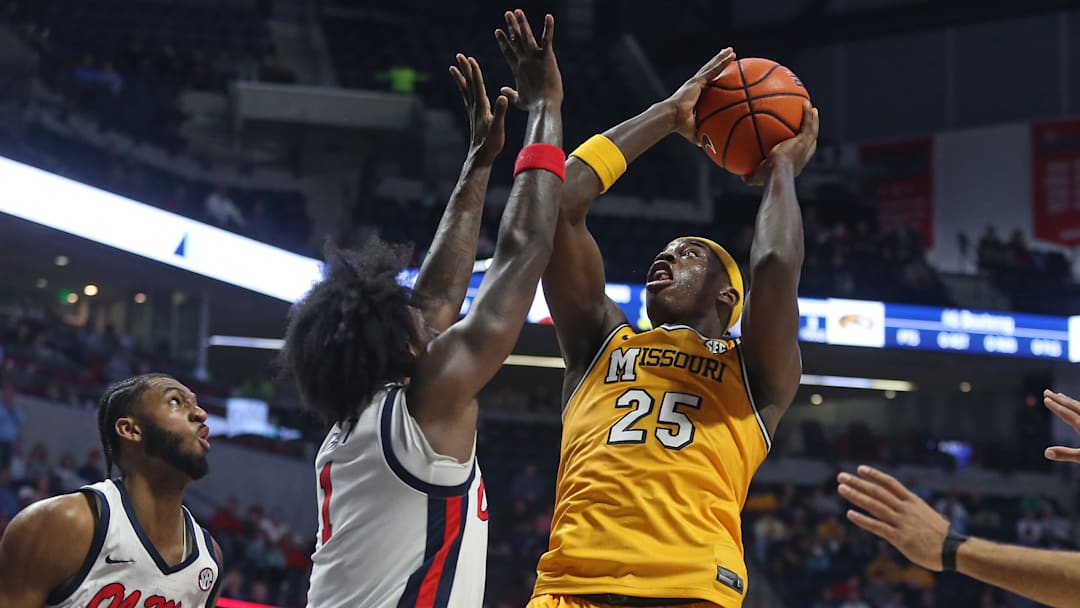 Jan 10, 2026; Oxford, Mississippi, USA; Missouri Tigers guard/forward Mark Mitchell (25) shoots as Mississippi Rebels forward Corey Chest (1) defends during the first half at The Sandy and John Black Pavilion at Ole Miss.