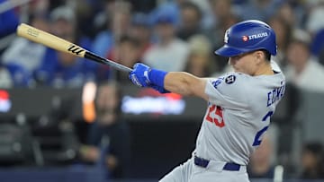 Oct 31, 2025; Toronto, Ontario, CAN; Los Angeles Dodgers second baseman Tommy Edman (25) hits a double in the third inning against the Toronto Blue Jays during game six of the 2025 MLB World Series at Rogers Centre. Mandatory Credit: John E. Sokolowski-Imagn Images