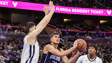 Feb 21, 2025; Orlando, Florida, USA; Orlando Magic forward Tristan da Silva (23) passes the ball in front of Memphis Grizzlies center Zach Edey (14) during the second quarter at Kia Center. Mandatory Credit: Mike Watters-Imagn Images