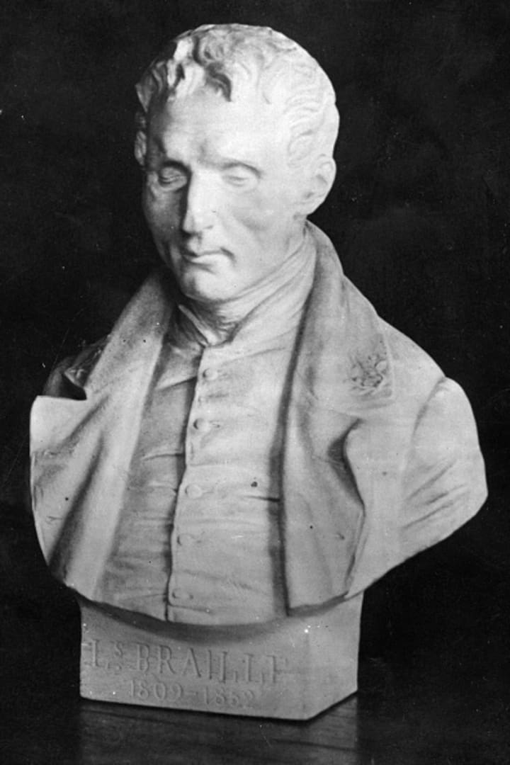 A black and white picture of a marble bust of Louis Braille.