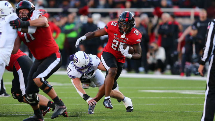 Nov 2, 2023; Lubbock, Texas, USA; Texas Tech Red Raiders running back Tahj Brooks (28) rushes against Texas Christian Horned Frogs defensive linebacker Johnny Hodges (57) in the first half at Jones AT&T Stadium and Cody Campbell Field. Mandatory Credit: Michael C. Johnson-USA TODAY Sports