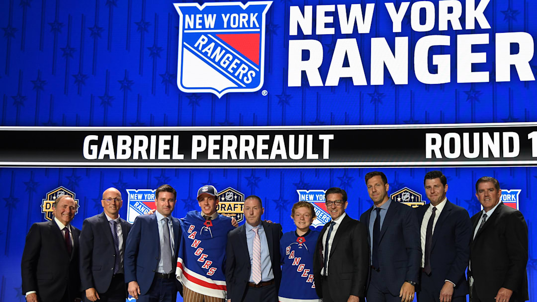 Jun 28, 2023; Nashville, Tennessee, USA; New York Rangers draft pick Gabriel Perreault stands with Rangers staff after being selected with the twenty third pick in round one of the 2023 NHL Draft at Bridgestone Arena. Mandatory Credit: Christopher Hanewinckel-Imagn Images