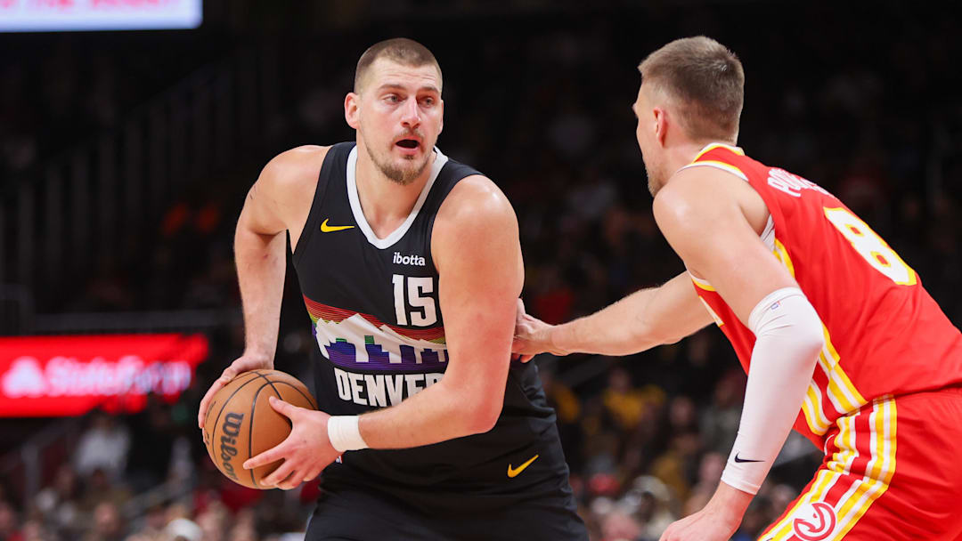 Dec 5, 2025; Atlanta, Georgia, USA; Denver Nuggets center Nikola Jokic (15) is defended by Atlanta Hawks center Kristaps Porzingis (8) in the fourth quarter at State Farm Arena. Mandatory Credit: Brett Davis-Imagn Images