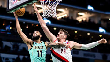 Jan 24, 2025; Charlotte, North Carolina, USA; Charlotte Hornets forward Cody Martin (11) shoots around Portland Trail Blazers center Donovan Clingan (23) during the first quarter at Spectrum Center. Mandatory Credit: Scott Kinser-Imagn Images
