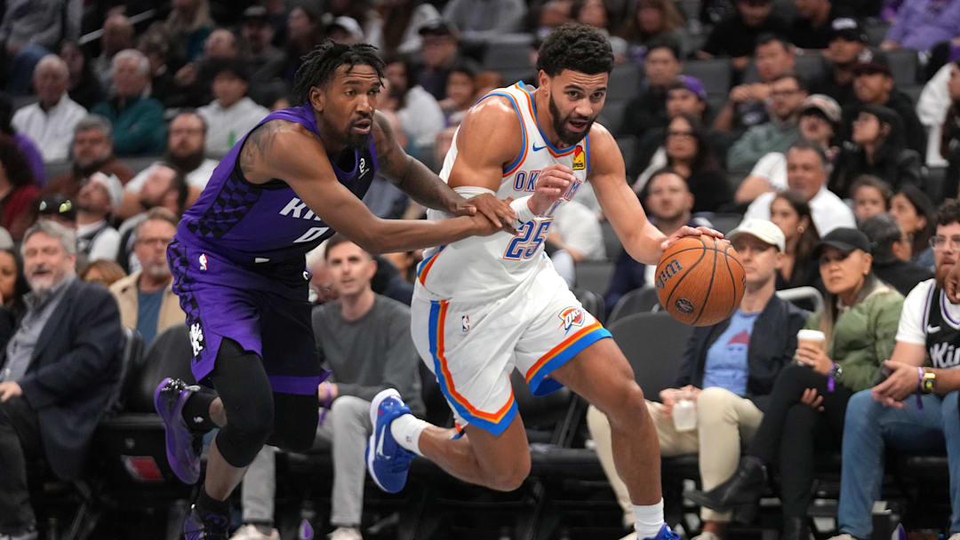 Nov 7, 2025; Sacramento, California, USA; Oklahoma City Thunder guard Ajay Mitchell (25) dribbles past Sacramento Kings guard Malik Monk (0) in the third quarter at the Golden 1 Center. Mandatory Credit: Cary Edmondson-Imagn Images