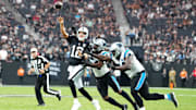 Sep 22, 2024; Paradise, Nevada, USA; Las Vegas Raiders quarterback Aidan O'Connell (12) makes a touchdown pass under pressure from Carolina Panthers linebacker Shaq Thompson (54) and Carolina Panthers defensive end A'Shawn Robinson (94) during the fourth quarter at Allegiant Stadium. Mandatory Credit: Stephen R. Sylvanie-Imagn Images