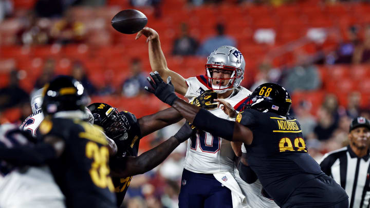 Aug 25, 2024; Landover, Maryland, USA; New England Patriots quarterback Drake Maye (10) is pressured by Washington Commanders defensive tackle Haggai Ndubuisi (68) and defensive tackle Daron Payne (94) during the first quarter during a preseason game at Commanders Field. Mandatory Credit: Peter Casey-USA TODAY Sports