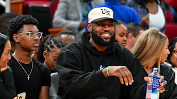 LeBron sits with his son, Bryce, and wife, Savannah.