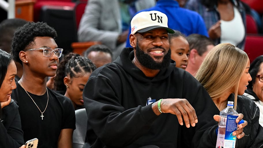 LeBron sits with his son, Bryce, and wife, Savannah. | Maria Lysaker-Imagn Images
