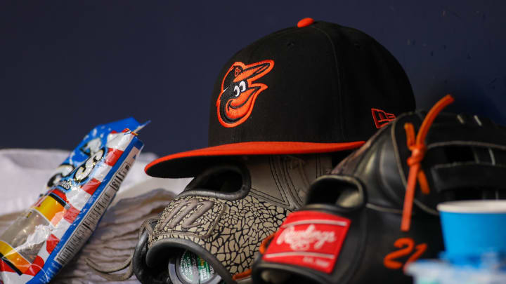 May 6, 2023; Atlanta, Georgia, USA; A detailed view of a Baltimore Orioles hat and glove in the dugout against the Atlanta Braves in the first inning at Truist Park. Mandatory Credit: Brett Davis-USA TODAY Sports