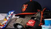 May 6, 2023; Atlanta, Georgia, USA; A detailed view of a Baltimore Orioles hat and glove in the dugout against the Atlanta Braves in the first inning at Truist Park.