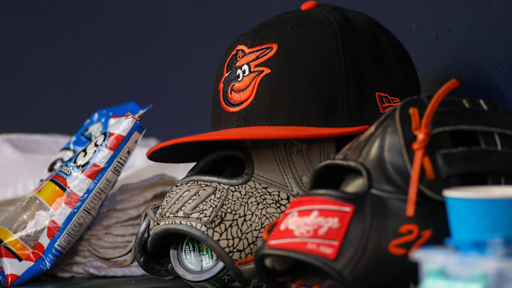 May 6, 2023; Atlanta, Georgia, USA; A detailed view of a Baltimore Orioles hat and glove in the dugout against the Atlanta Braves in the first inning at Truist Park. May 6, 2023; Atlanta, Georgia, USA; A detailed view of a Baltimore Orioles hat and glove in the dugout against the Atlanta Braves in the first inning at Truist Park.