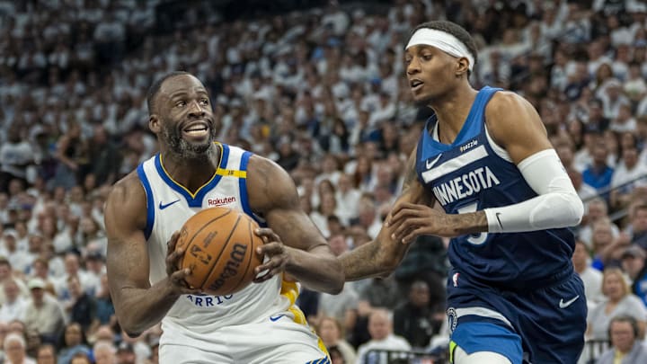 Golden State Warriors forward Draymond Green drives to the basket past Minnesota Timberwolves forward Jaden McDaniels.