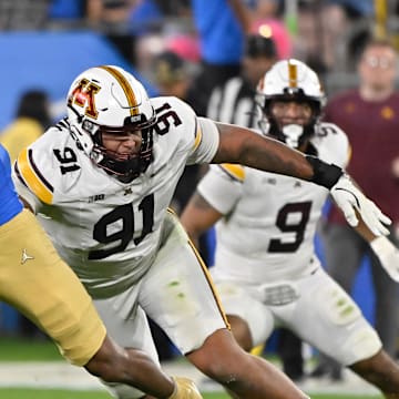 Oct 12, 2024; Pasadena, California, USA; UCLA Bruins wide receiver Kwazi Gilmer (3) runs past Minnesota Golden Gophers defensive lineman Deven Eastern (91) during the second quarter  at Rose Bowl. Mandatory Credit: Robert Hanashiro-Imagn Images